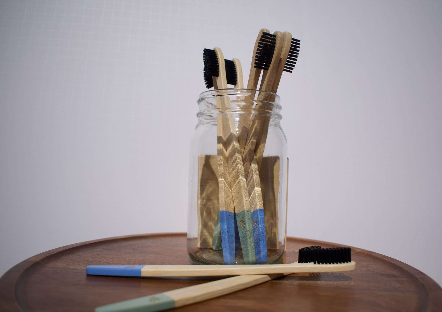 Bamboo toothbrushes in a jar, showcasing eco-friendly design and colorful handles for family use.