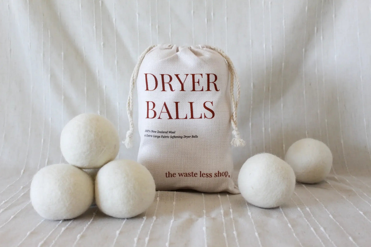 Eco-friendly wool dryer balls by The Wasteless Shop in a bag, promoting sustainable laundry alternatives.